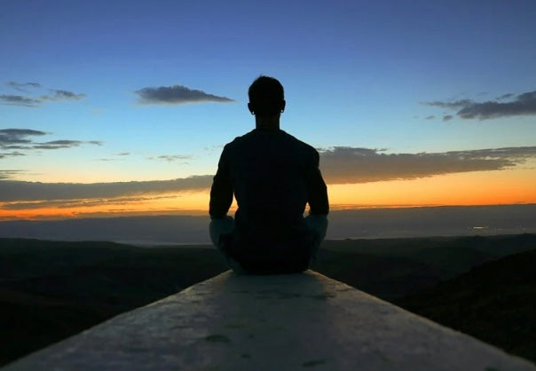 A man looking at the sunset maintaining the well-being of skin, body, and mind.